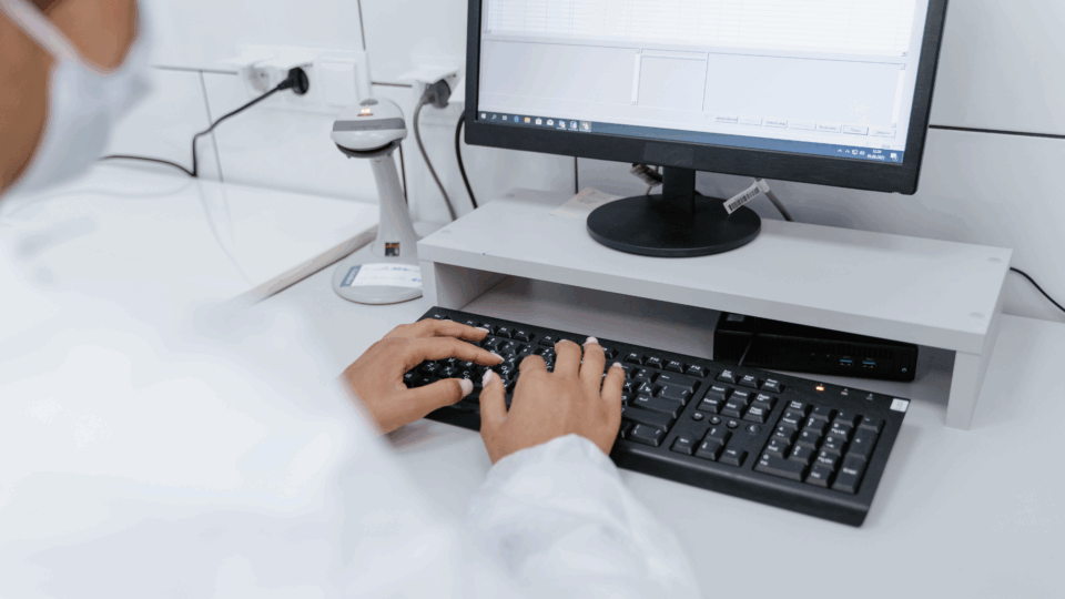 Doctor working on computer, sending HIPAA-compliant faxes