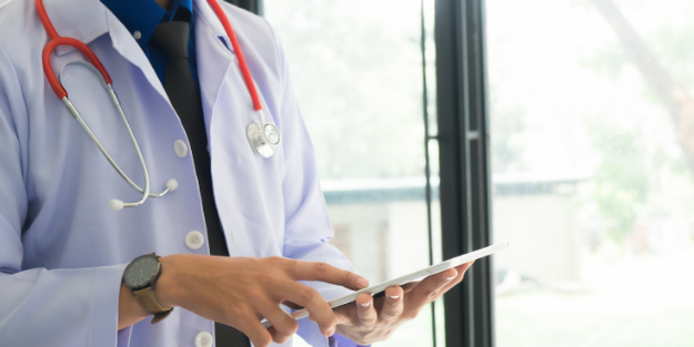 Doctor looking at tablet and touching it with their index finger