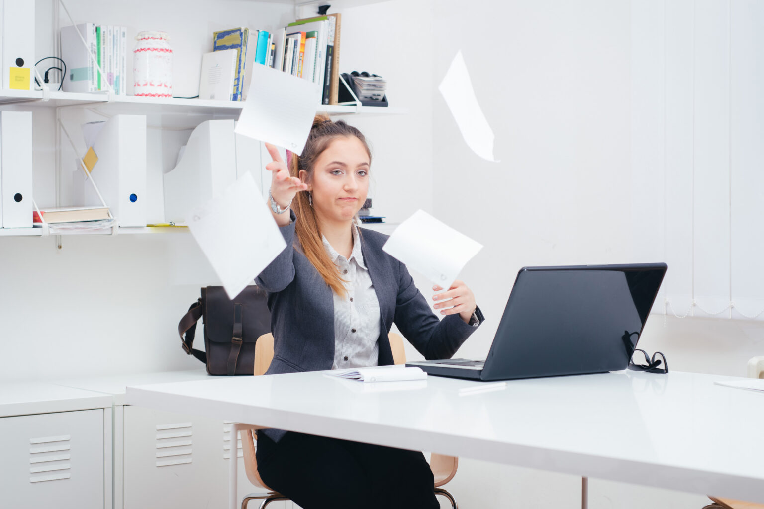 Young business woman throwing documents in frustration that her fax solution is not working well