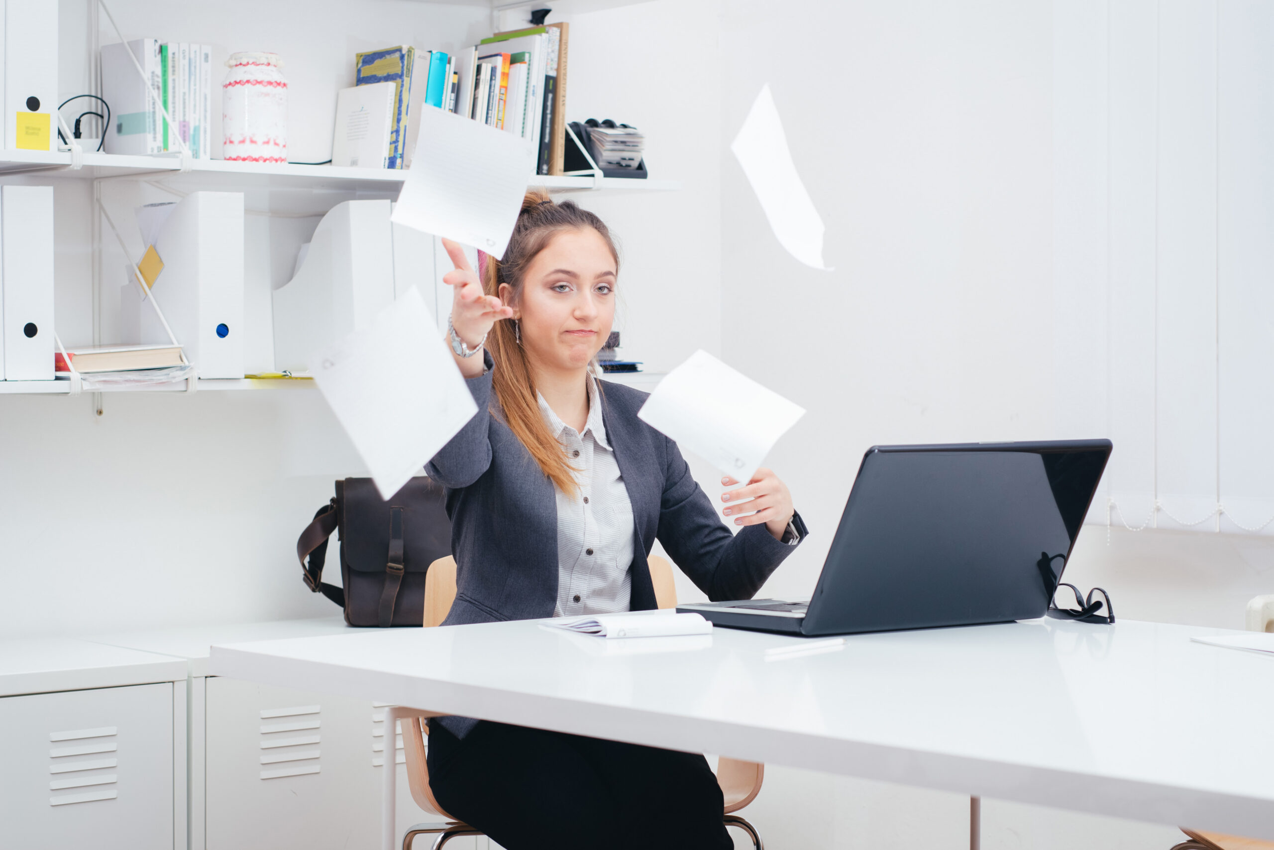 Young business woman throwing documents in frustration that her fax solution is not working well