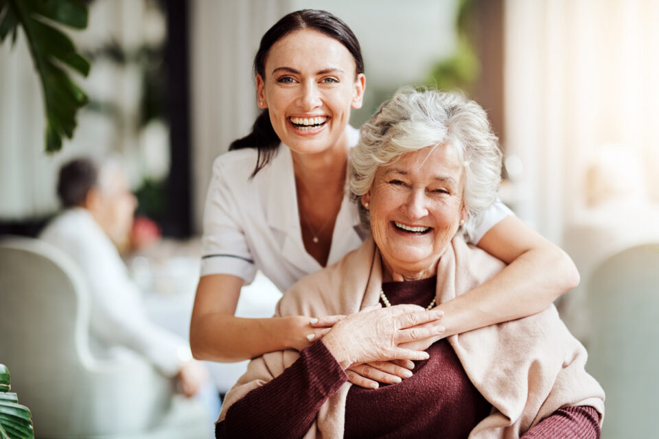 Portrait of a young nurse embracing an elderly woman in a retirement home