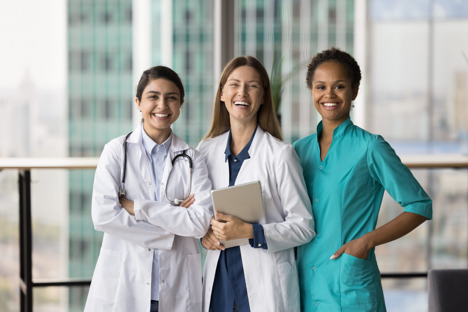 Cheerful medical team of doctors standing together, looking at camera