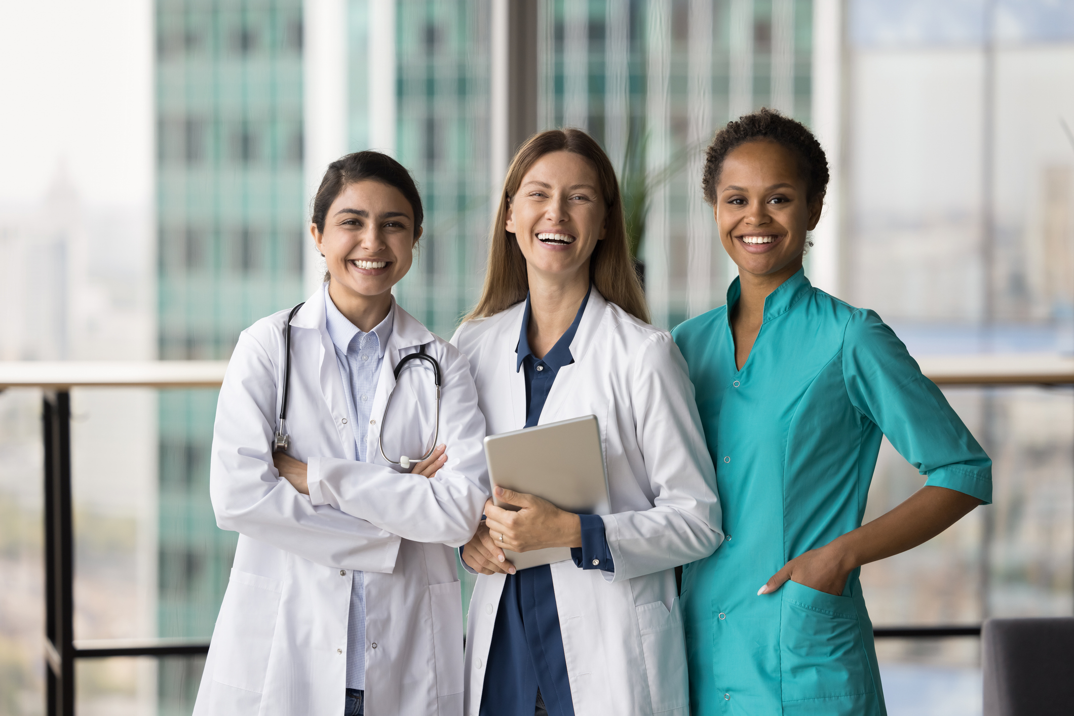 Cheerful medical team of doctors standing together, looking at camera