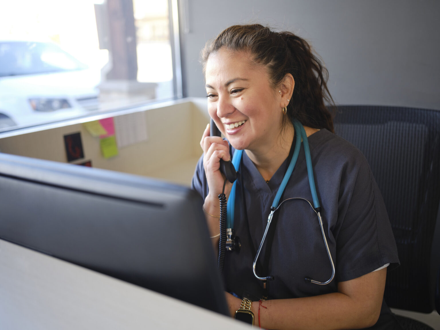 A healthcare working at a reception desk in an office