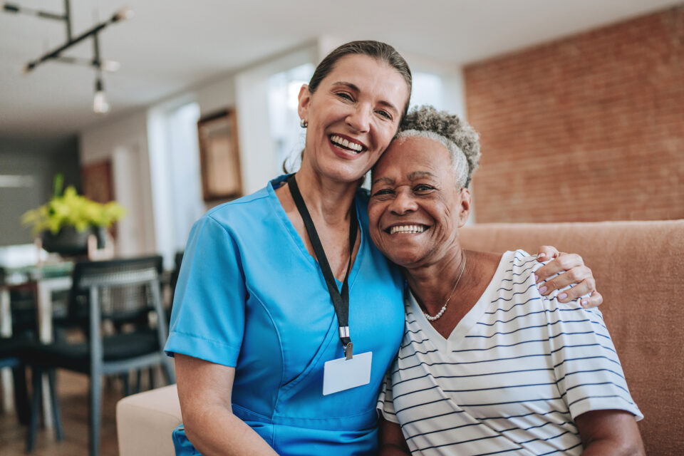 Healthcare professional hugging elderly patient